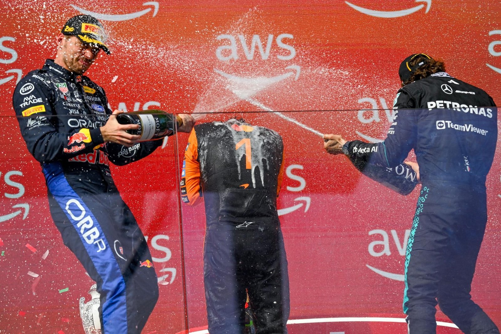 El piloto de Red Bull Max Verstappen, de los Países Bajos (izquierda), que quedó en segundo lugar, y el piloto de Mercedes Andrea Kimi Antonelli (derecha), que quedó en tercer lugar, rocían con agua al ganador, el piloto de McLaren Lando Norris, de Gran Bretaña (centro), mientras celebran en el podio tras el Gran Premio de Hungría de Fórmula 1.